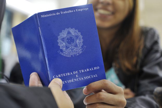 mulher segurando carteira de trabalho representando clt ou pj